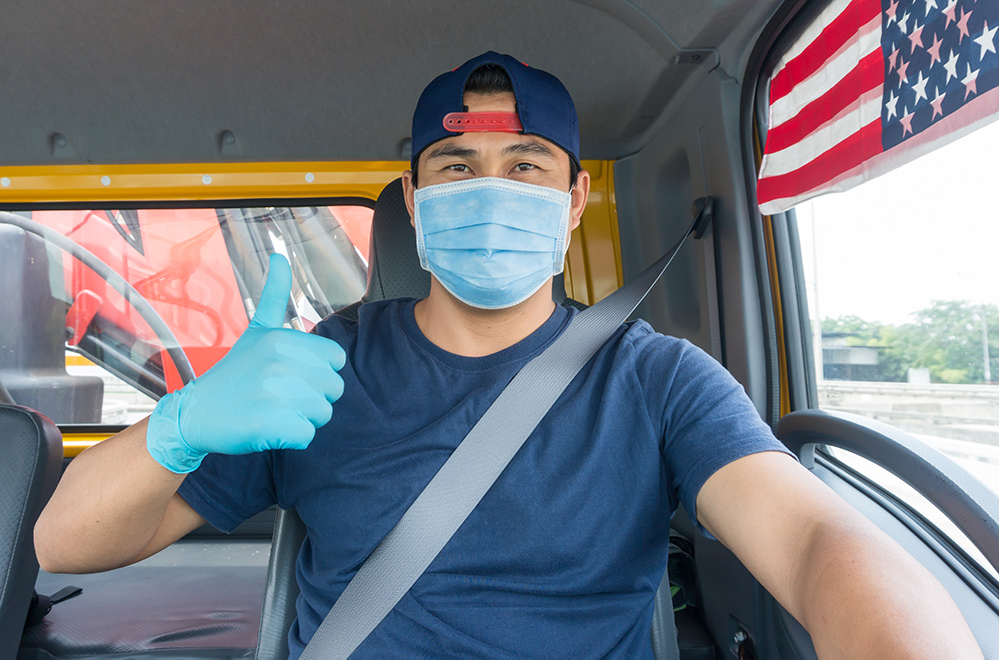 Truck driver with mask and gloves on.